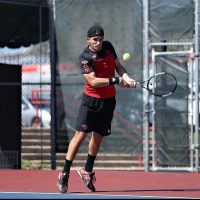 Nedim is playing tennis.